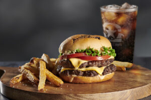 A BurgerFi meal – juicy cheeseburger, crispy fries, and refreshing Coke.