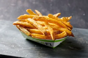 A close-up of a basket overflowing with perfectly golden French fries.