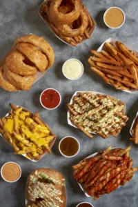 A tempting spread of crispy fries, golden onion rings, and various dipping sauces, ready to satisfy your cravings.