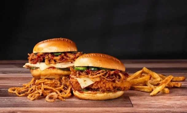 A delicious plate of burgers and fries, featuring two juicy burgers with all the fixings and a generous side of crispy fries.