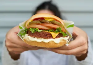 lady holding burgerfi cheese burger