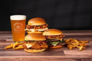 Table full of burgers,fries and drink