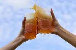 Two people clicking two BurgerFi beer cups. 